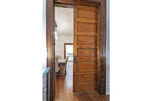 Hall with dark wood-style flooring and crown molding