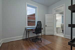 Home office with dark wood-style floors and baseboards