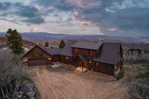 View of front of property with dirt driveway, a mountain view, and a metal roof