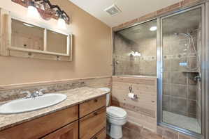 Full bath with vanity, a stall shower, and tile patterned floors