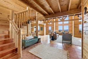 Tiled living area with a high wood beamed ceiling and wood walls
