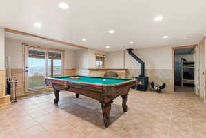 Recreation room with wainscoting, billiards, a wood stove, recessed lighting, and light tile patterned flooring