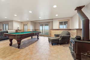 Rec room with a wainscoted wall, a wood stove, pool table, and recessed lighting