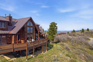 Back of property featuring a deck, a chimney, and a standing seam roof