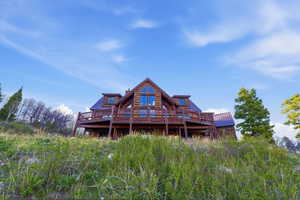 Back of house featuring a deck and a metal roof