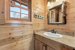 Bathroom featuring wooden walls and vanity