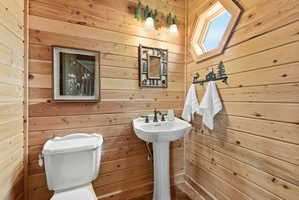 Half bathroom with wooden walls and toilet