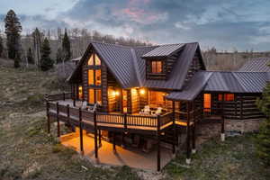 Back of house at dusk featuring a deck and a metal roof