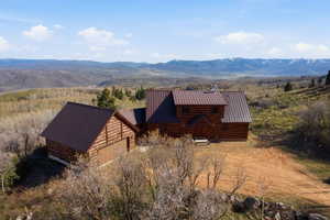 Aerial view of property and surrounding area featuring a mountainous background