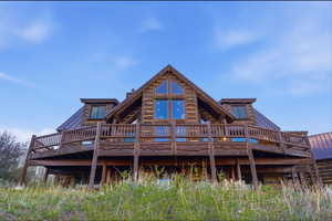 Back of property with a wooden deck and a metal roof