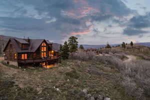 Back of house with a wooden deck and a standing seam roof