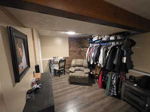 Walk in closet with wood finished floors and a paneled ceiling