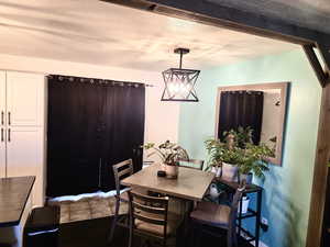 Dining area featuring a textured ceiling and suspended lighting