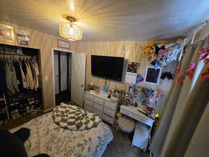 Bedroom with a closet and dark colored carpet