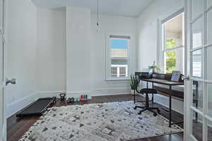 Office space featuring dark wood-style flooring and baseboards