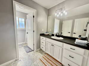 Full bathroom featuring vanity and light marble finish flooring