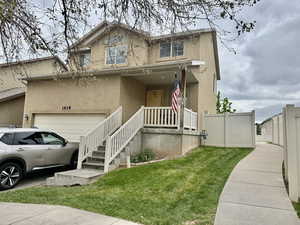 Traditional-style house featuring covered porch, stucco siding, and a garage