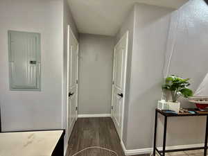 Hall featuring electric panel and dark wood-type flooring