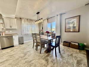 Dining space featuring a textured ceiling and light marble finish floors