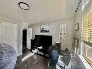 Home office with wood finished floors and a textured ceiling
