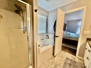 Full bathroom with vanity, ensuite bath, a stall shower, and a whirlpool tub