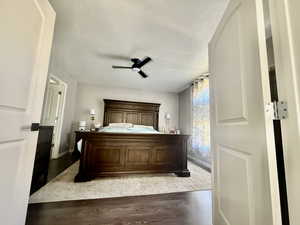 Bedroom featuring a textured ceiling, light wood-style flooring, and a ceiling fan