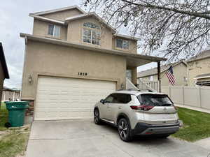 Traditional-style house with stucco siding, concrete driveway, a garage, and a porch
