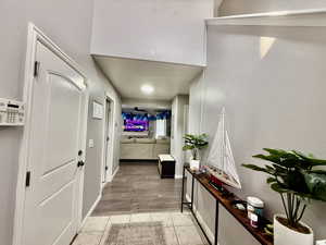 Hallway featuring light tile patterned floors and a textured wall