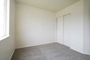 Unfurnished bedroom featuring carpet floors and a closet