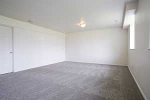 Carpeted spare room with baseboards