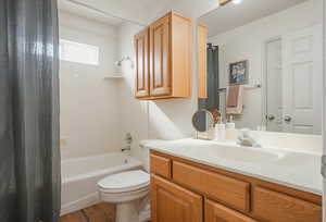 Bathroom featuring vanity, shower / tub combo with curtain, and light wood-style floors