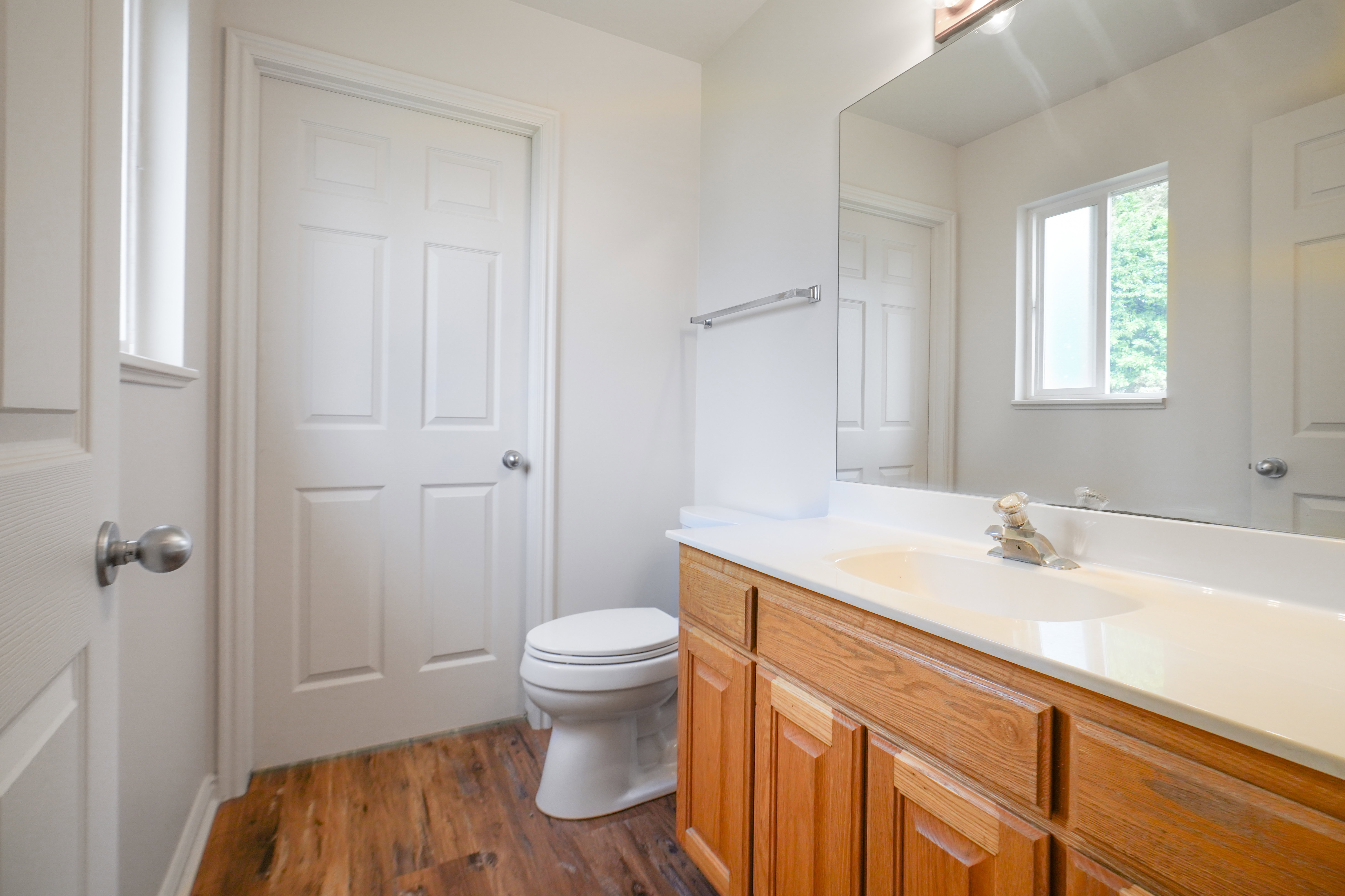 Half bathroom featuring vanity and dark wood-style flooring