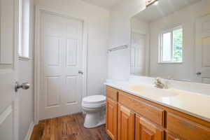 Half bathroom featuring vanity and dark wood-style flooring