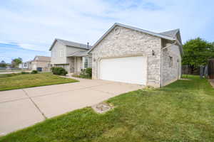 View of front of home featuring a garage, driveway, brick siding, and roof with shingles