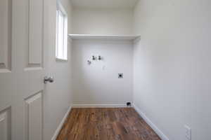 Laundry area with dark wood-type flooring, washer hookup, and electric dryer hookup
