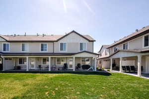 Rear view of house featuring a lawn, a patio, and board and batten siding