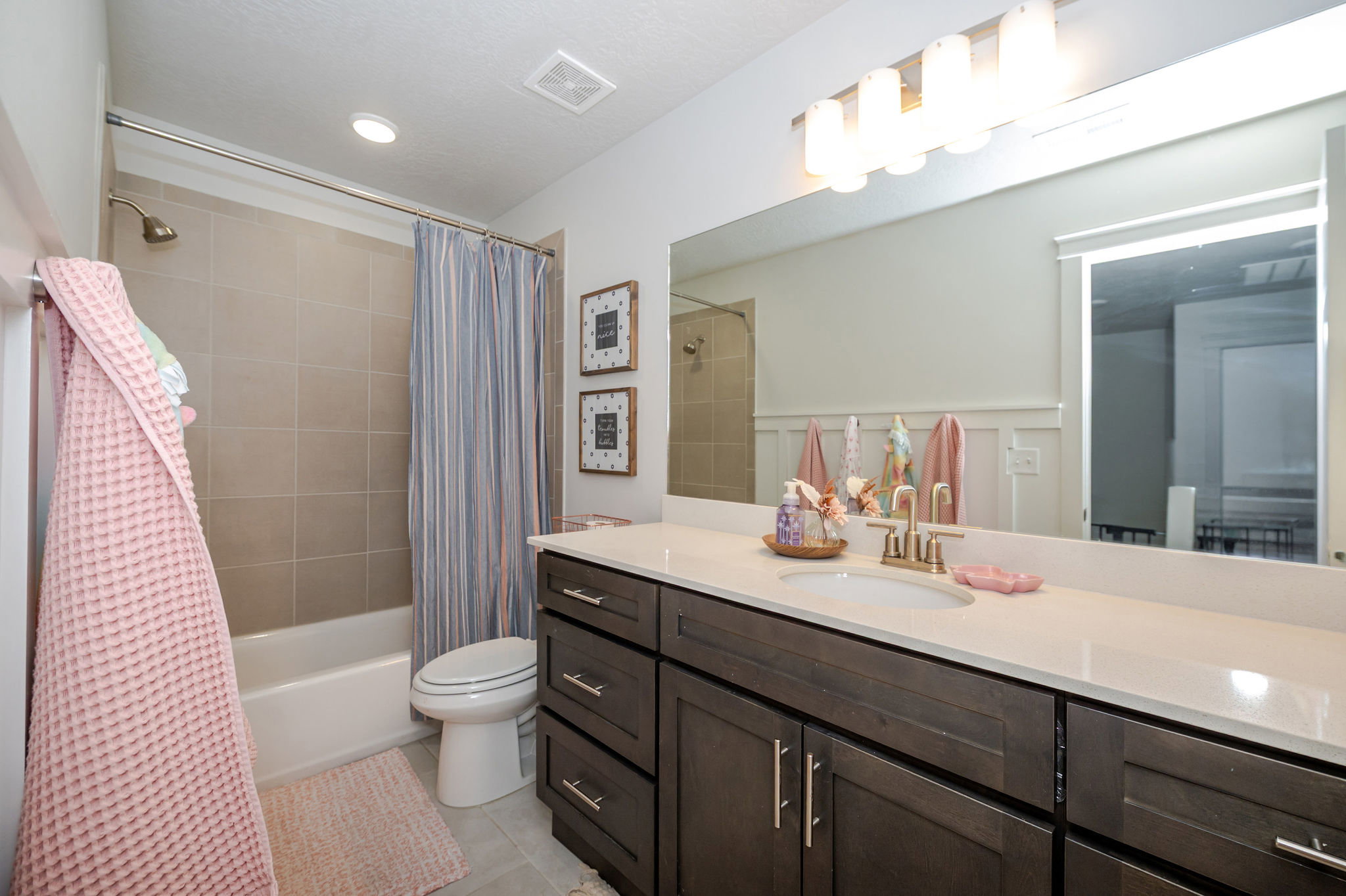 Full bathroom featuring vanity, shower / bath combo with shower curtain, and light tile patterned floors