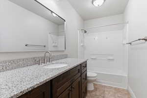 Full bath featuring vanity, tub / shower combination, and light tile patterned floors