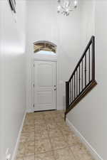 Entryway featuring a high ceiling, light tile patterned floors, and hanging lights
