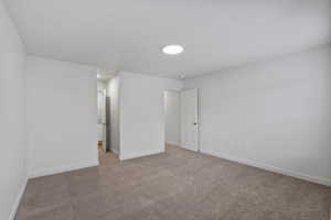 Unfurnished bedroom with baseboards and carpet
