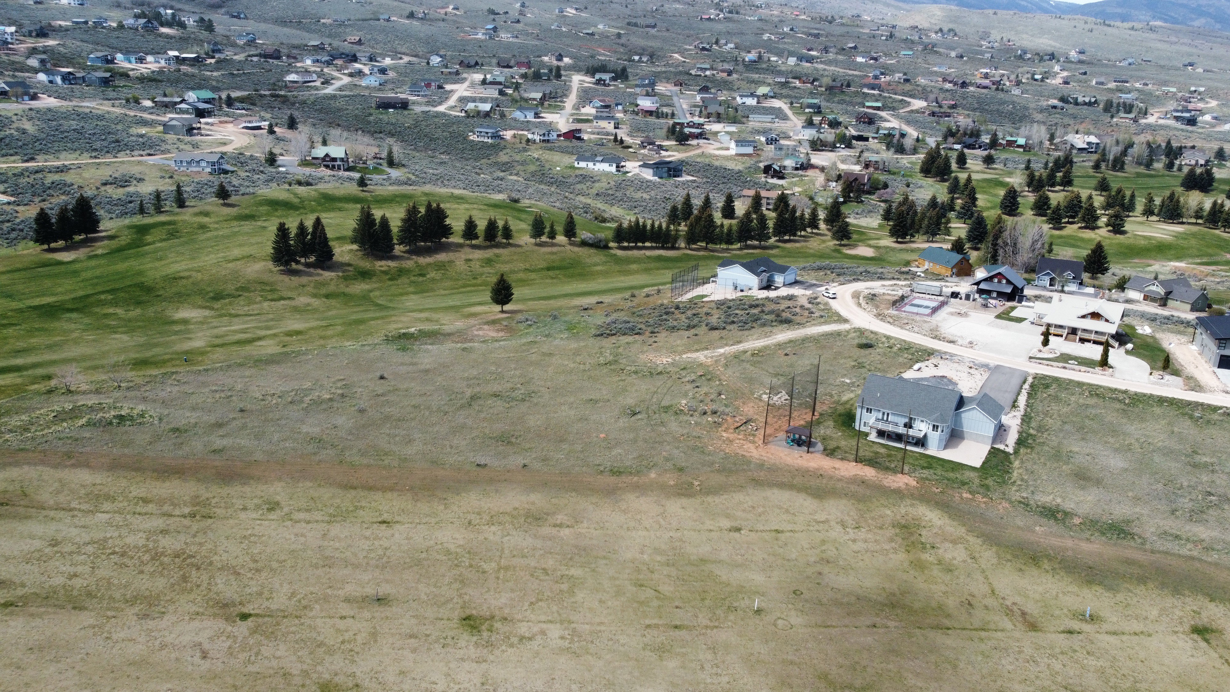 View of property location featuring mountains, nearby suburban area, and a golf club