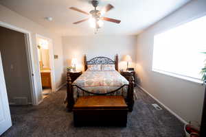 Carpeted main bedroom with ceiling fan and connected bathroom