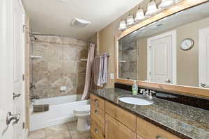 Bathroom with vanity, shower / bath combination with curtain, and light tile patterned floors