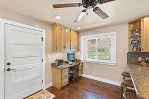 Office with built in study area, a ceiling fan, dark wood-type flooring, and recessed lighting