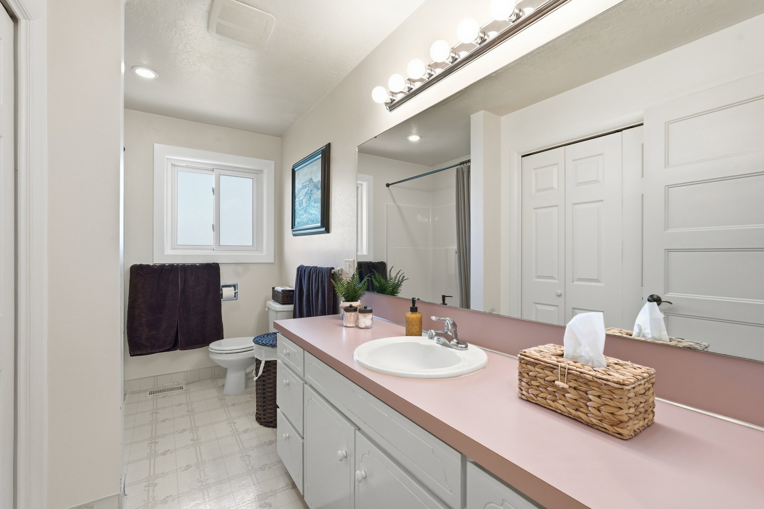 Bathroom featuring light flooring, a closet, vanity, a shower stall, and recessed lighting