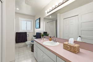 Bathroom featuring light flooring, a closet, vanity, a shower stall, and recessed lighting