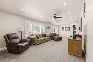 Living area featuring light colored carpet, ceiling fan, recessed lighting, and vaulted ceiling