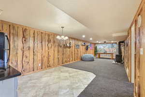 Playroom with recessed lighting, light tile patterned flooring, light colored carpet, wood walls, and a gas stove