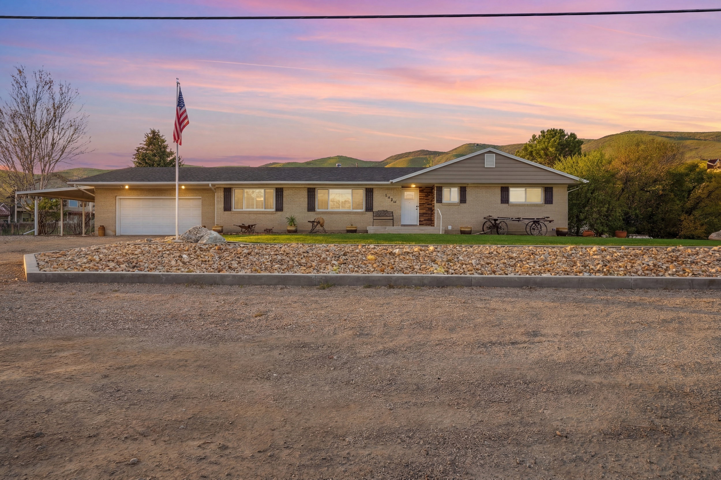 Single story home featuring brick siding, a garage, a carport, and driveway