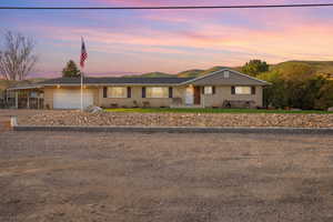 Single story home featuring brick siding, a garage, a carport, and driveway